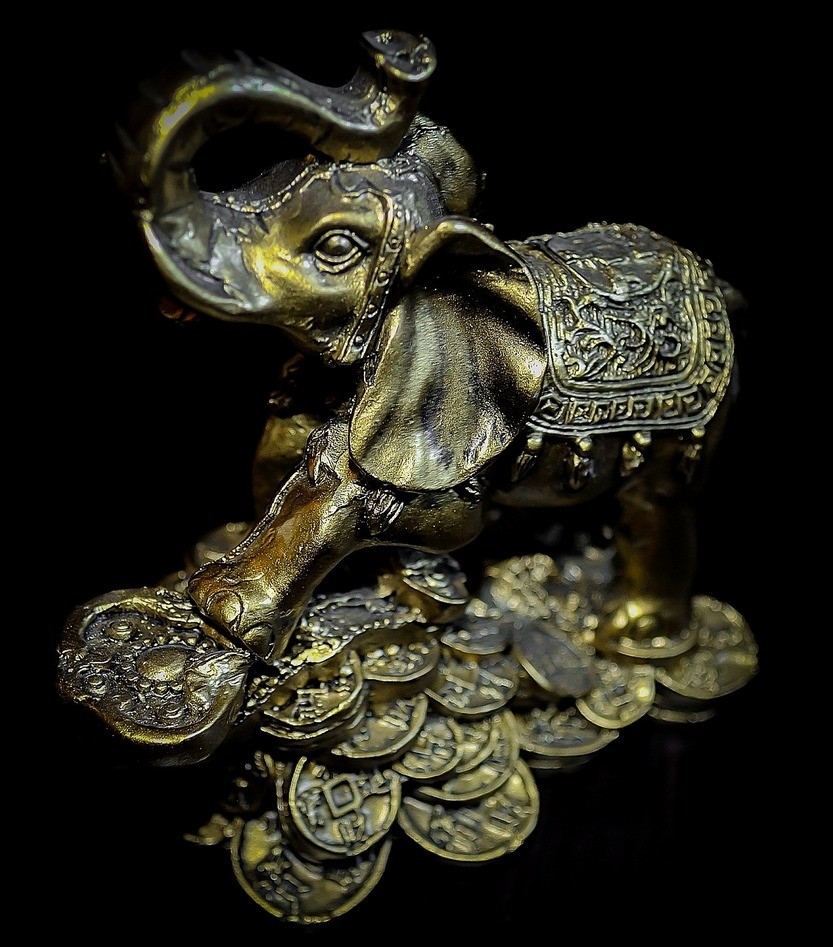Слон на горсти золотых монет
